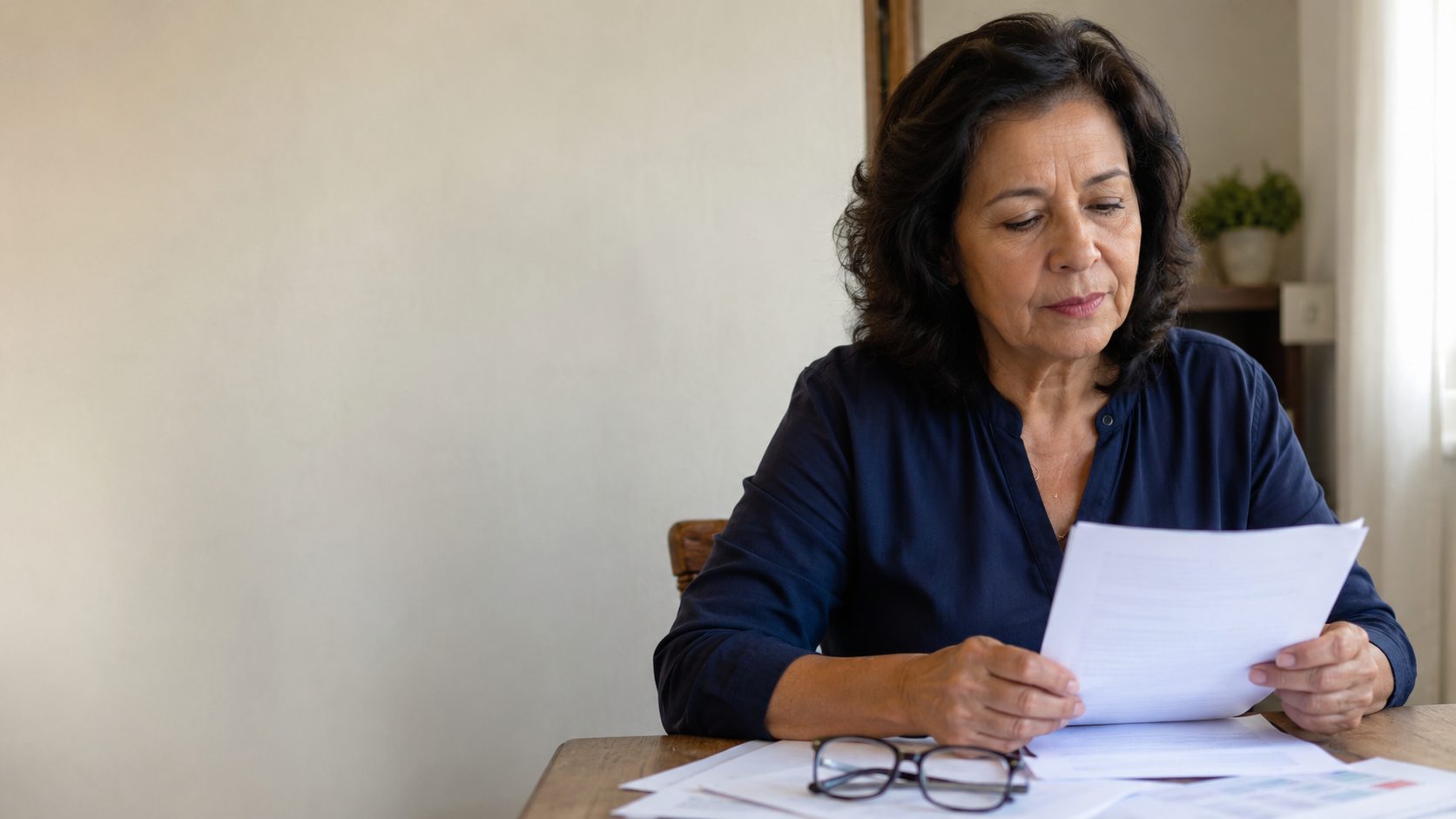 Mulher lendo documentos à mesa